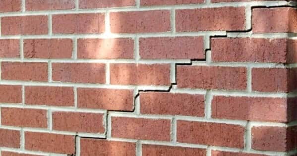 A brick wall with cracks on its facing due to foundation settlement.