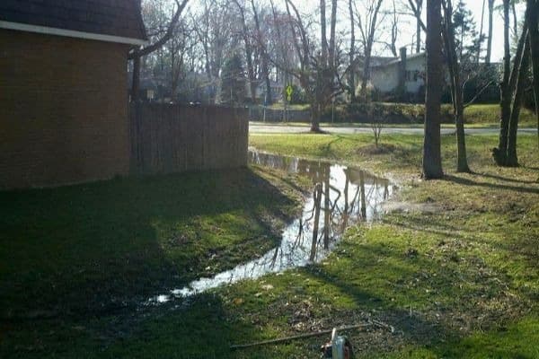 A yard experiencing flooding from poor water drainage solutions.