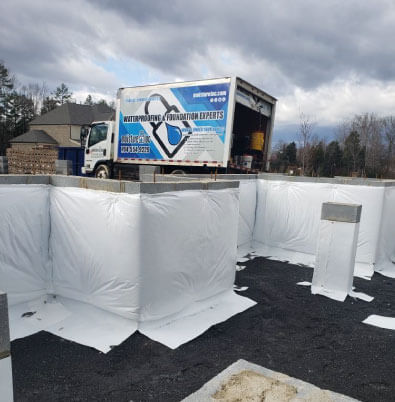 A Moisture Loc basement waterproofing foundation repair truck sits at a commercial repair site.