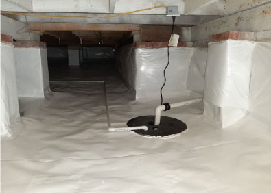 A crawlspace is equipped with piping for basement waterproofing foundation repair solutions.